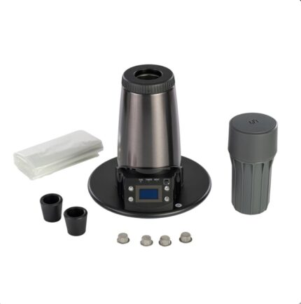 Electric countertop beverage maker with a stainless conical top, circular base, and small digital display; includes accessories like a mug, adapters, and caps.